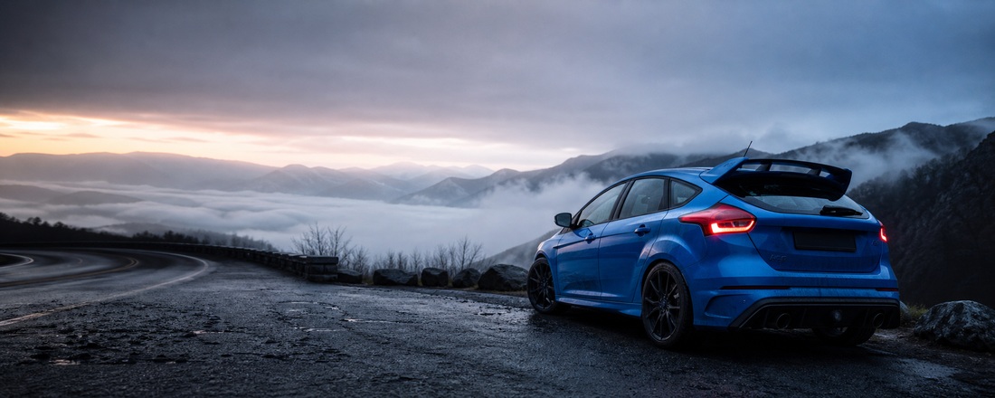 Blue Focus RS-style hot hatch at a mountain overlook at dawn