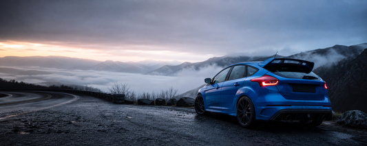 Blue Focus RS-style hot hatch at a mountain overlook at dawn